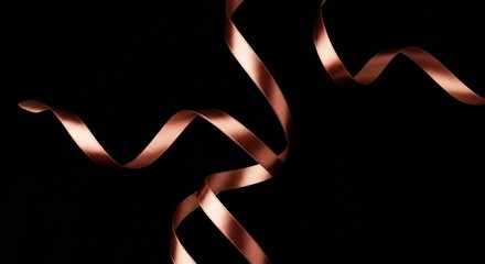 Copper ribbon twirls against a solid black background creating curves and shine