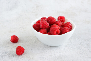 Close-up of a bowl filled with fresh ripe raspberries with a realistic style