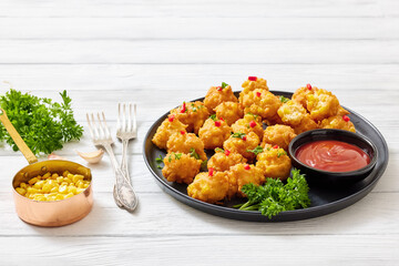 corn nuggets on a plate with tomato sauce