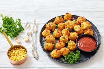 corn nuggets on a plate with tomato sauce