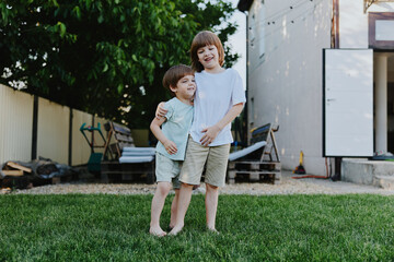 Joyful boys playing together in a backyard, showcasing friendship and happiness. Their laughter...