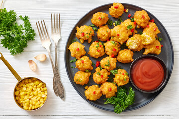 corn nuggets on a plate with tomato sauce