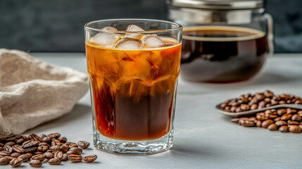 Fototapeta premium A refreshing glass of iced coffee sits next to glossy coffee beans and a portafilter, showcasing the beauty of espresso artistry in a bright, modern setting