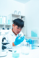 Scientist using micropipette for laboratory experiment in modern science lab. Concept of chemical...