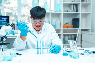 Fototapeta premium Scientist using micropipette for laboratory experiment in modern science lab. Concept of chemical research, liquid analysis, biotechnology, precision science, healthcare and diagnostics.