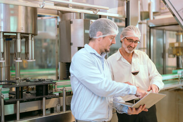 Two professionals discuss quality control in a food processing plant during working hours while...