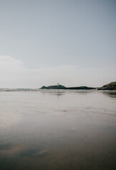 A beach with a lighthouse in the distance
