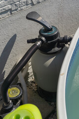 Swimming pool pump and filter system next to a murky pool, concept of pool maintenance, home...