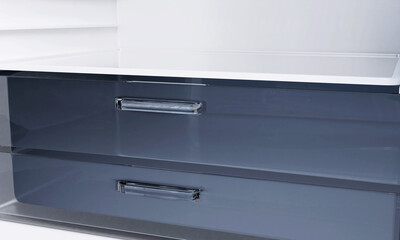 Shelves in empty open white fridge