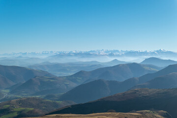 Vasta paisagem dos Pirenéus a partir de Artzamendi no País Basco francês, com montanhas nevadas...