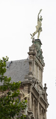 Fototapeta premium The statue of Hermes on the historic buildings on the street Leysstraat in Antwerp