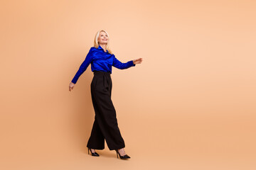 Confident businesswoman in stylish formal attire walking against beige background, illustrating...