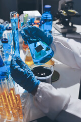 Scientist pipetting medical samples into microplate in laboratory