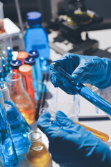 Scientist pipetting medical samples into microplate in laboratory