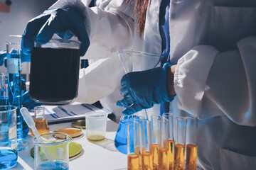 Scientist pipetting medical samples into microplate in laboratory