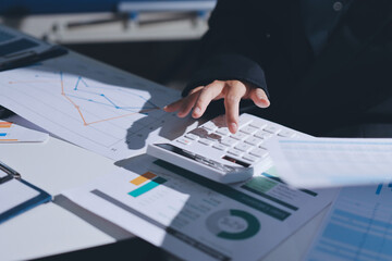 Group of business women working on a financial data expenses document.
