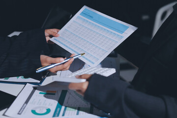 Group of business women working on a financial data expenses document.