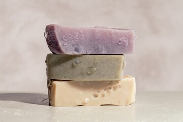 Three handmade soap bars are arranged in a stack, featuring vibrant colors and unique surface textures, highlighting their artisanal quality