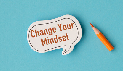 A white sticker with the words Change Your Mindset written on it. A pencil is next to the sticker