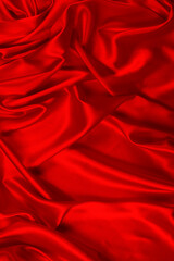 Red silk or satin luxury fabric texture can use as abstract background. Top view.
