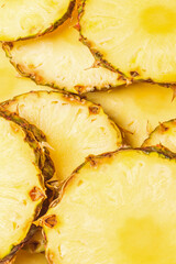 Pineapple juicy yellow slices background. Top view.