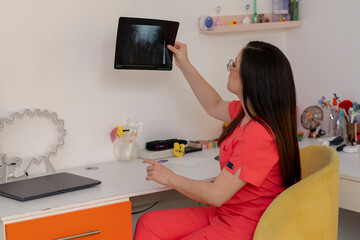 Pediatrician examining x-ray in colorful office