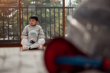 Before the tournament day, a boy dressed in fencing gear are rehearsing in gym