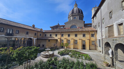 Obraz premium Monastery Courtyard with Fountain and Flower Garden