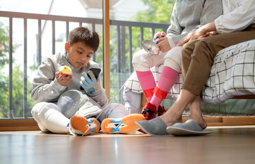Fototapeta premium A girl and boy in fencing gear with their mother preparing food and sports equipment