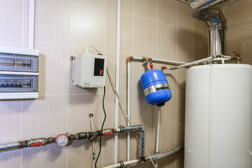 tiled room features a water heater, blue expansion tank, pipes, a fuse box, and an electrical...
