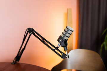 Mic stand with silver microphone ready for podcast recording in a cozy studio setting