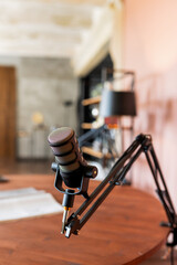 Podcast microphone setup on a wooden desk in a contemporary recording studio environment