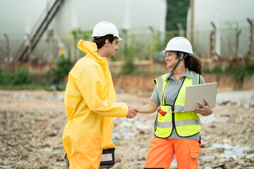 Male worker in hazmat gear shake hands with woman in safety vest, project agreement, work success, collaboration team, chemical plant site