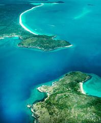 Aerial view of submerged reefs (green color) and surface clear waters (blue color) at Great Barrier Reef, the world's largest coral reef system in the Coral Sea near Whitsunday Island. Australia. 2020