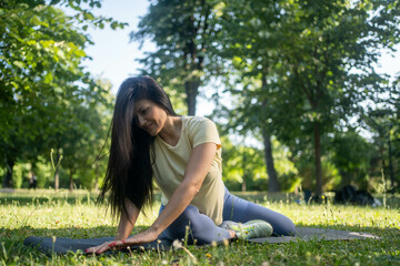 Beautiful woman stretching her leg in the park on a fresh morning, enjoying healthy lifestyle, calm...