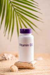 Bottle with capsules of the supplements vitamin d on the background of the sunny beach with sand in a white plastic jar. Vitamin D, fish oil. Healthy eating concept. High quality photo