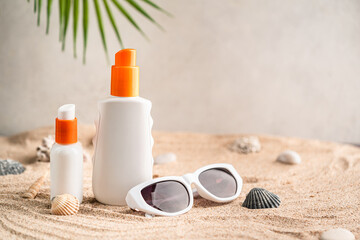 Sunblock or sunscreen in cosmetic tube on beach sand and beige background. Summer vacation and skin care concept with starfish and sea shells, spf uv-protect cosmetics. Skin health. High quality photo