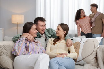 Friends hugging each other indoors, selective focus