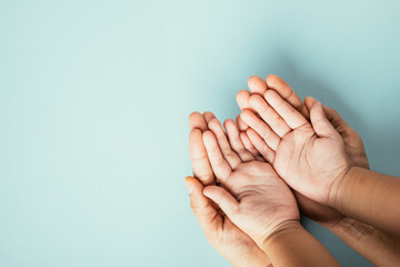 Family hands stack in close-up top view isolated background. Parents and child hold empty space together expressing support on Family and Parents Day.