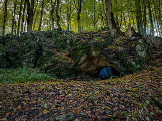 Körös-lyuk cave entrance seen from afar in its natural forest setting. A hidden karst cave at 932...