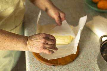 adult woman's hands unwrapping a package of sweet cream butter