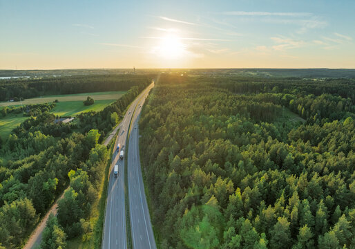 Aerial View of a Scenic Highway Surrounded by Lush Forest During Sunset