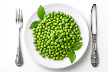 A plate of peas garnished with basil leaves sits between a fork and knife
