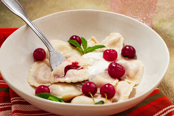 Traditional dumplings with cherries and yogurt, close-up, no people,