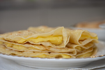 Thin qystybiy folded in half and stacked on a plate, filled with mashed potatoes, perfect for breakfast or a snack