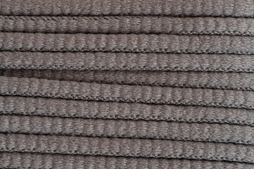 Grey textured fabric rolls displayed on flat surface in well-lit workshop