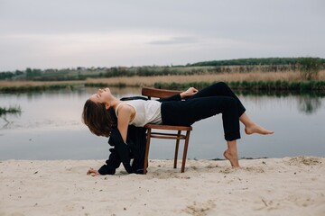 Young woman relaxing on chair by the lake during photo session
