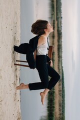 Businesswoman balancing on chair in surreal nature photo session