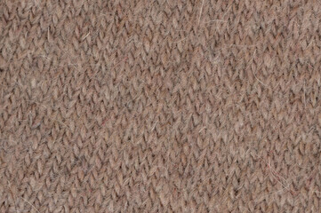 Textured knit fabric showcasing soft brown tones in close-up view of material