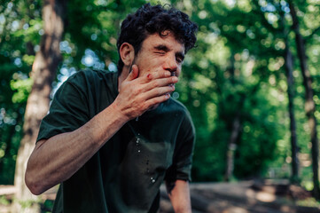 Injured hiker washing face in forest stream